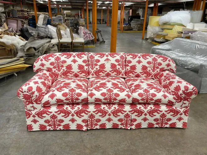 Red and white patterned sofa in a warehouse or furniture store aisle