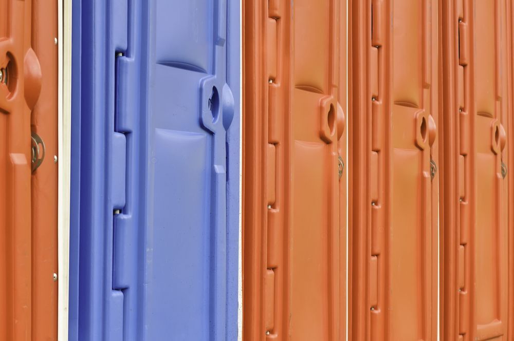 Colorful corrugated metal panels in orange and blue, with vertical ridges and door handles.