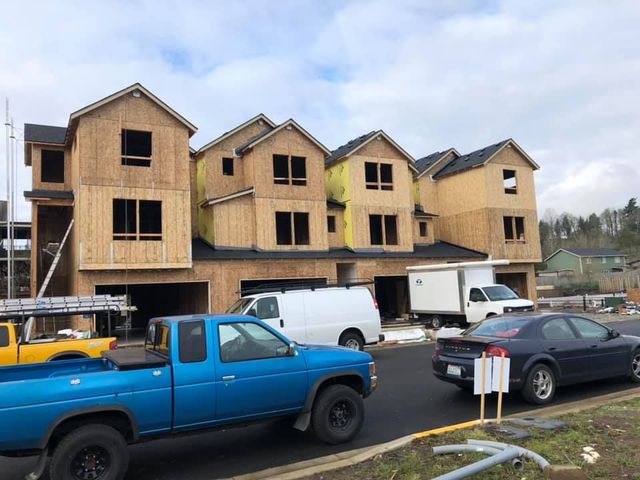 A blue truck is parked in front of a building under construction.