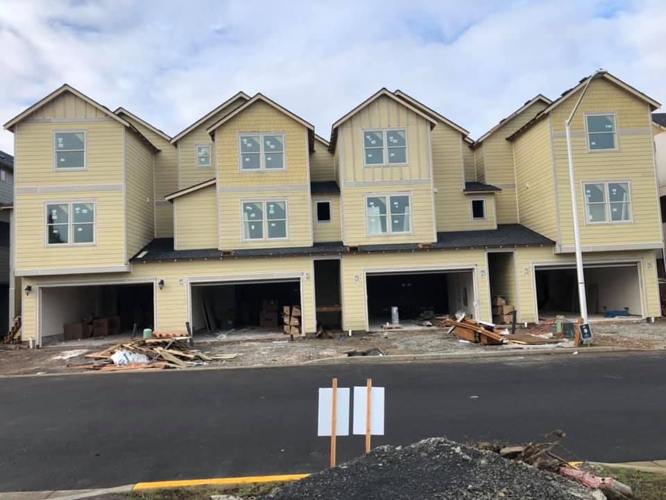 A row of yellow houses are being built next to each other.