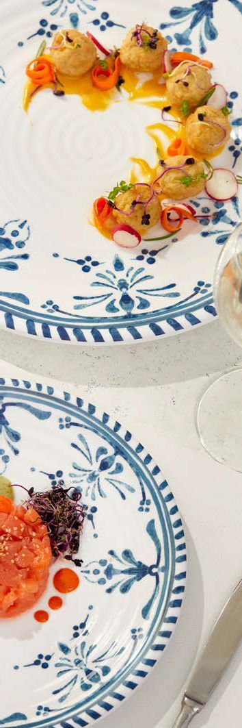 Piatti bianchi decorati con colorati stuzzichini su un tavolo da pranzo