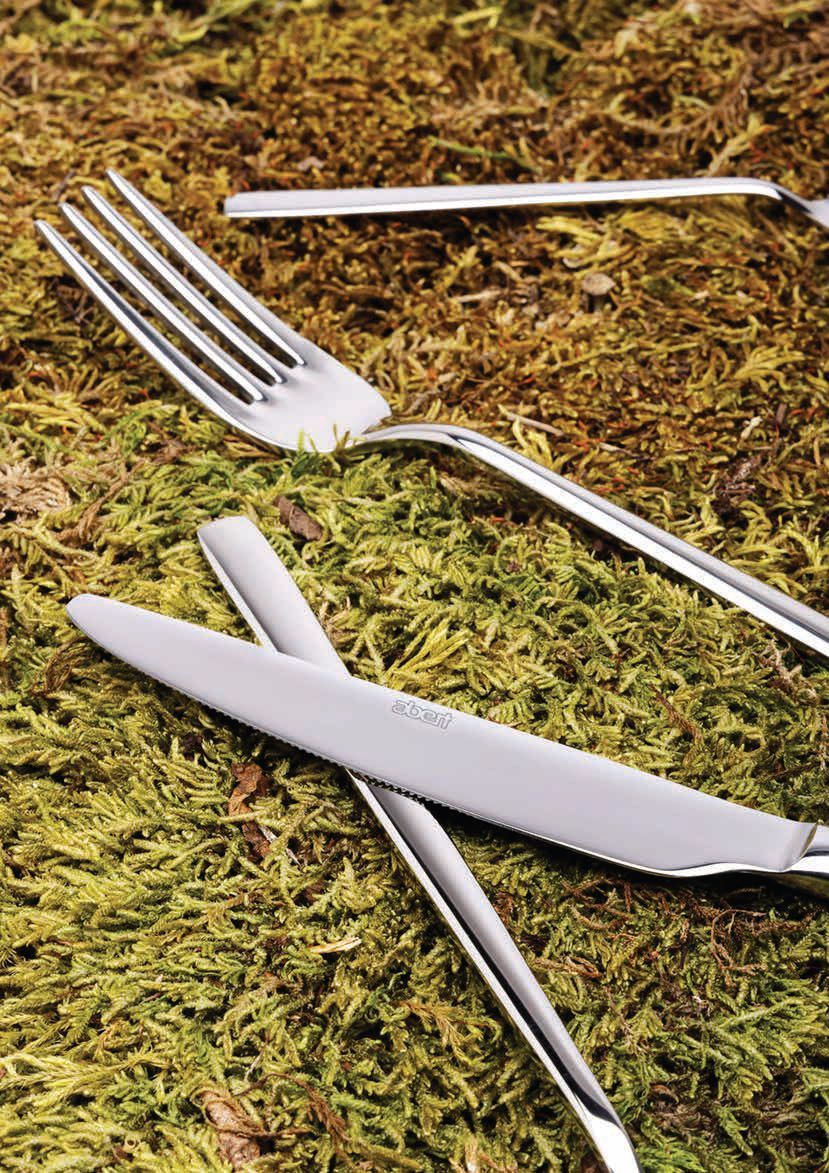 Forchetta, coltello e bacchette d'argento disposti su una superficie verde muschio.
