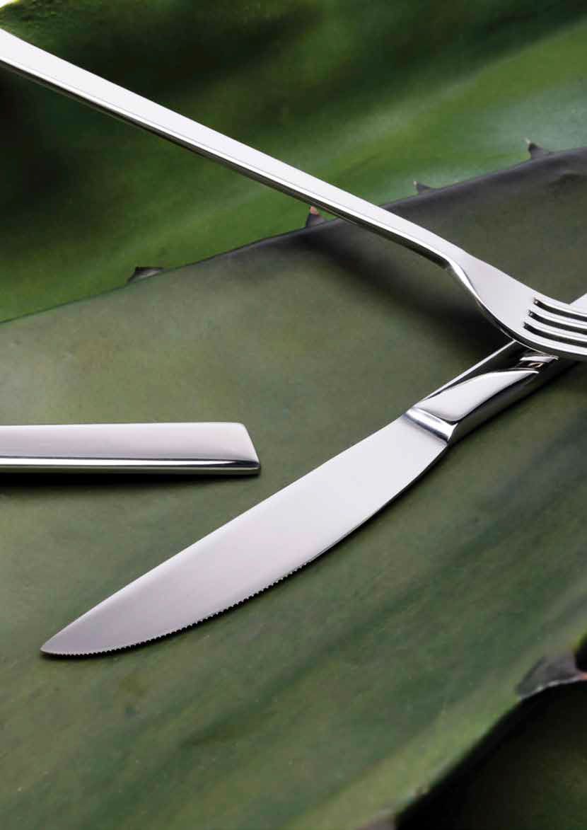 Forchetta e coltello su una tovaglietta a forma di foglia verde accanto a un tovagliolo piegato.