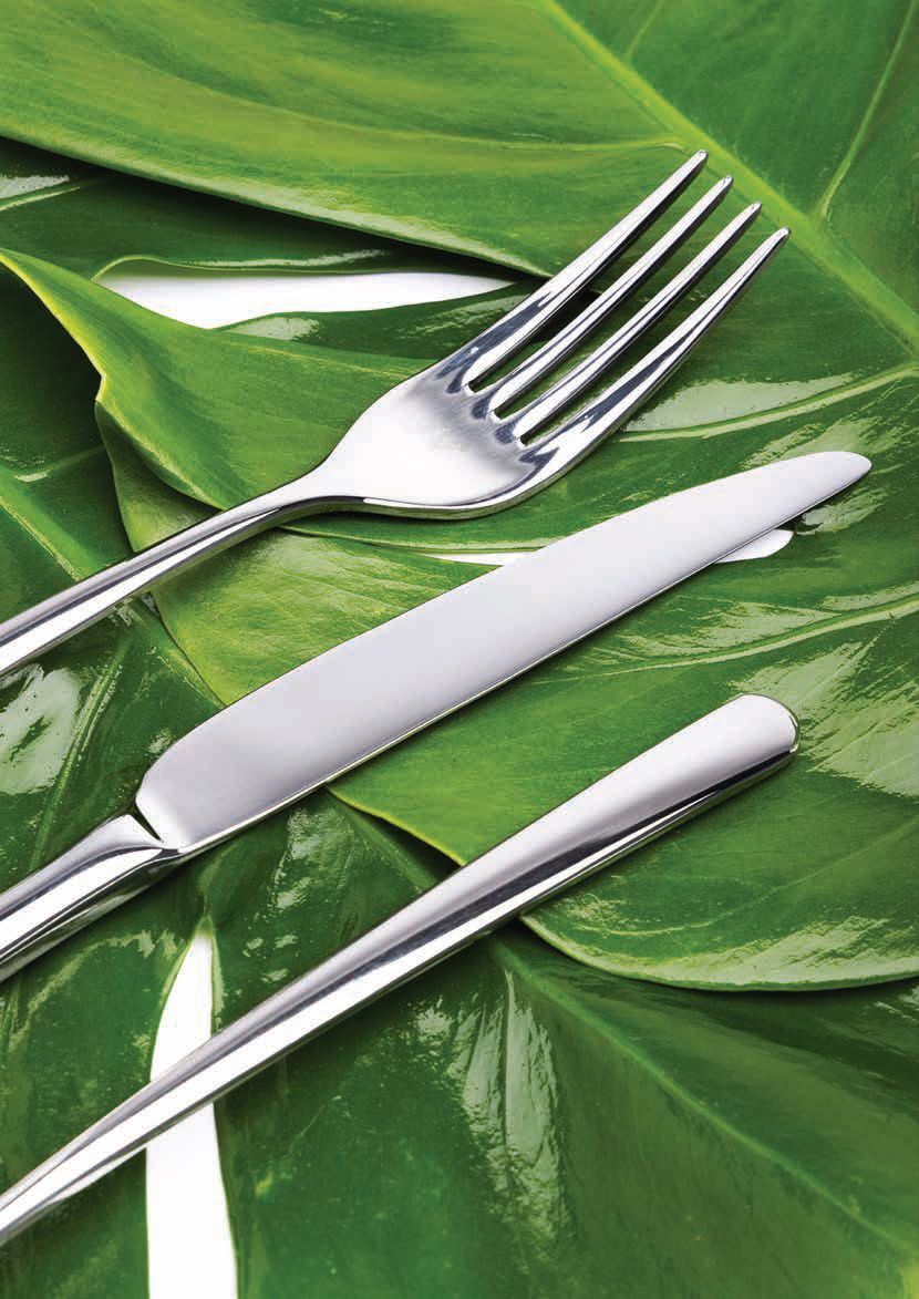 Forchetta e coltello d'argento su un tovagliolo bianco sopra foglie verdi lucide