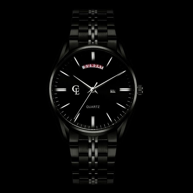 Black wristwatch with a black face and band, with white hands and markers, on a black background.