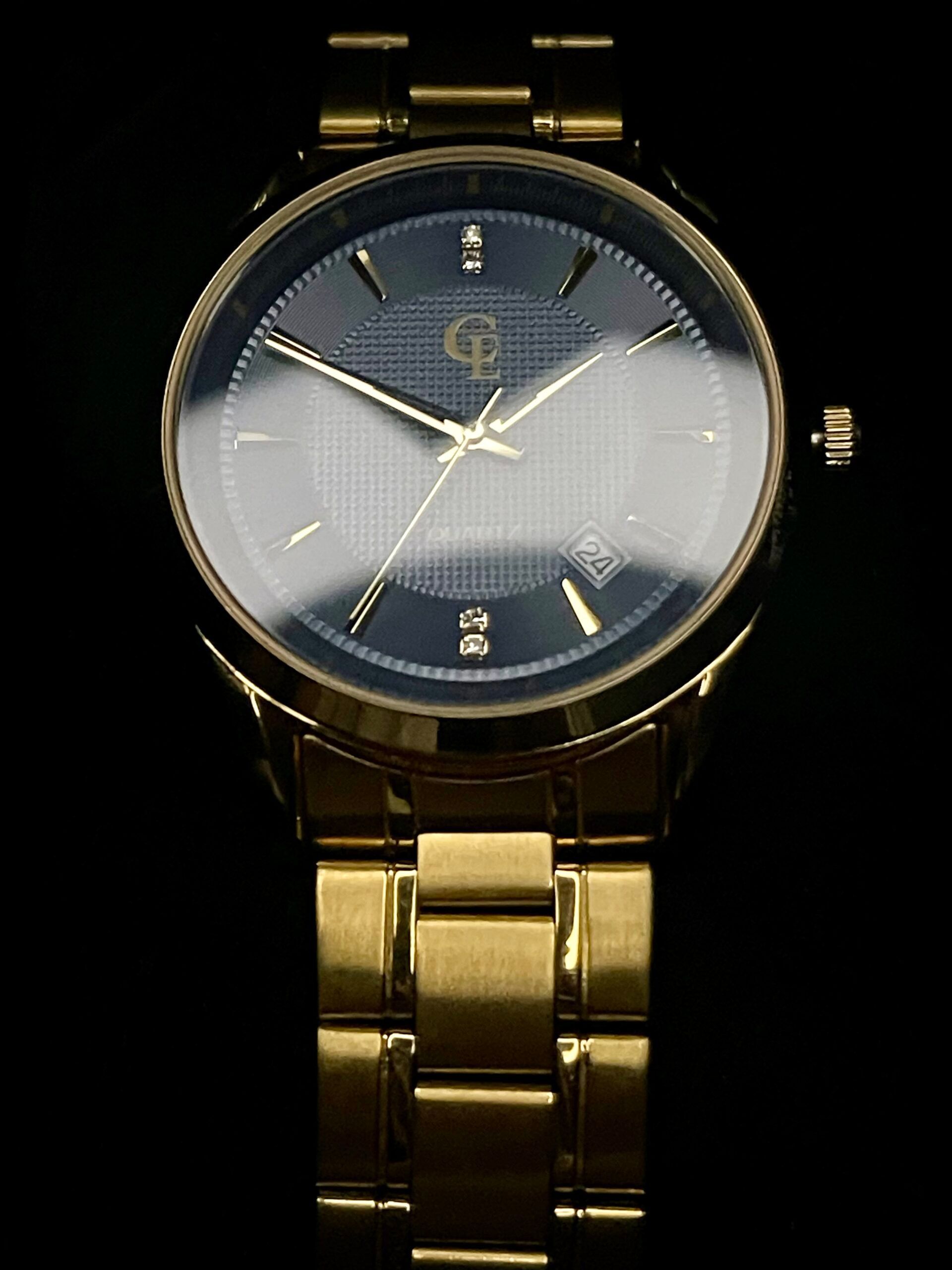 Gold wristwatch with black dial and gold hands and band.