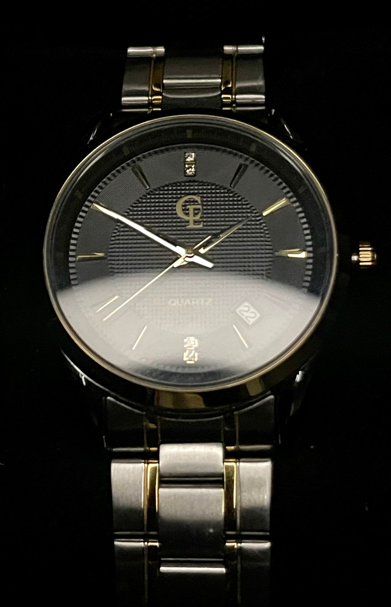 Black and silver wristwatch with gold accents, black face, and date display.