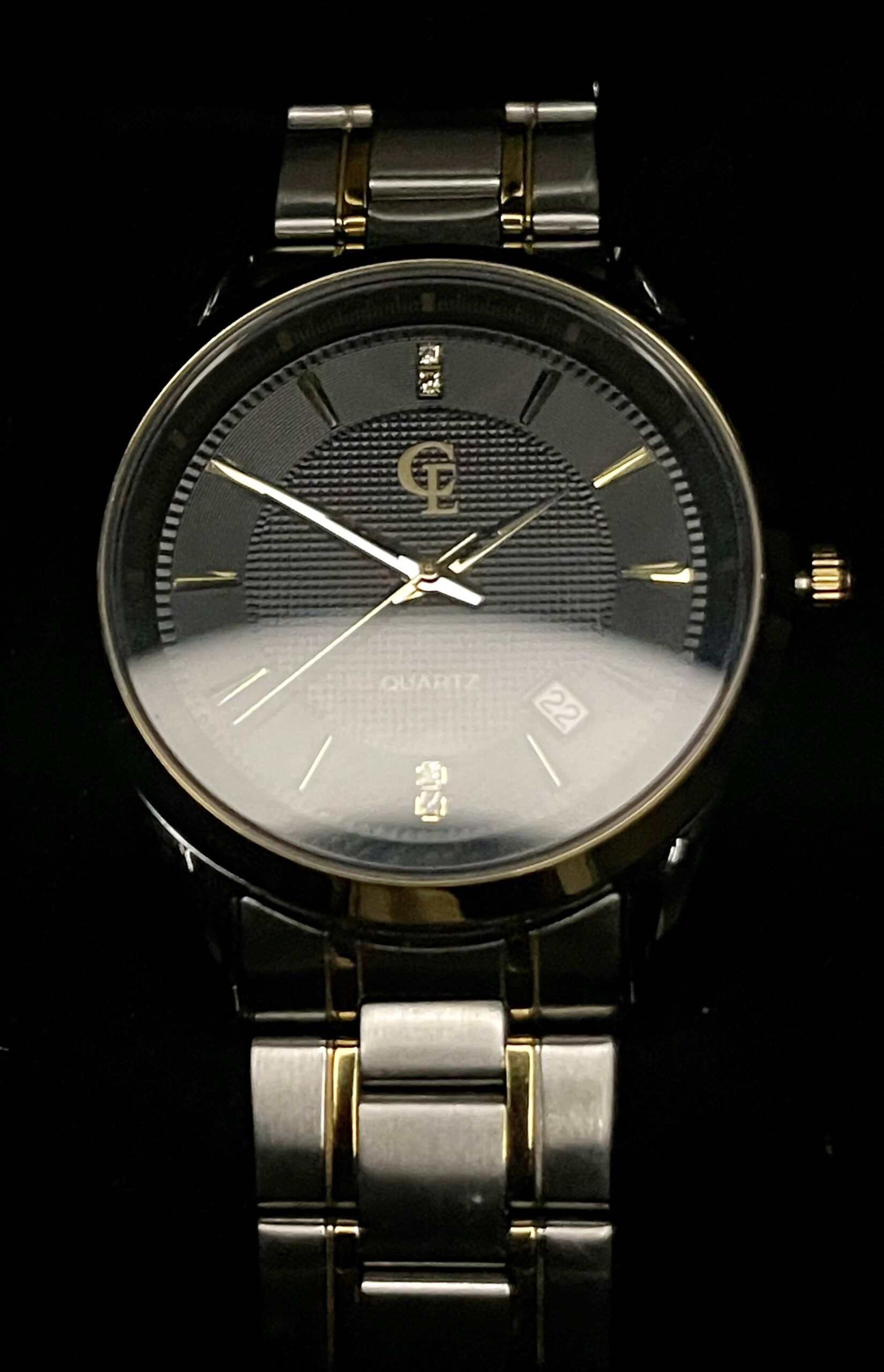 Silver and gold wristwatch with a black face and gold hands.