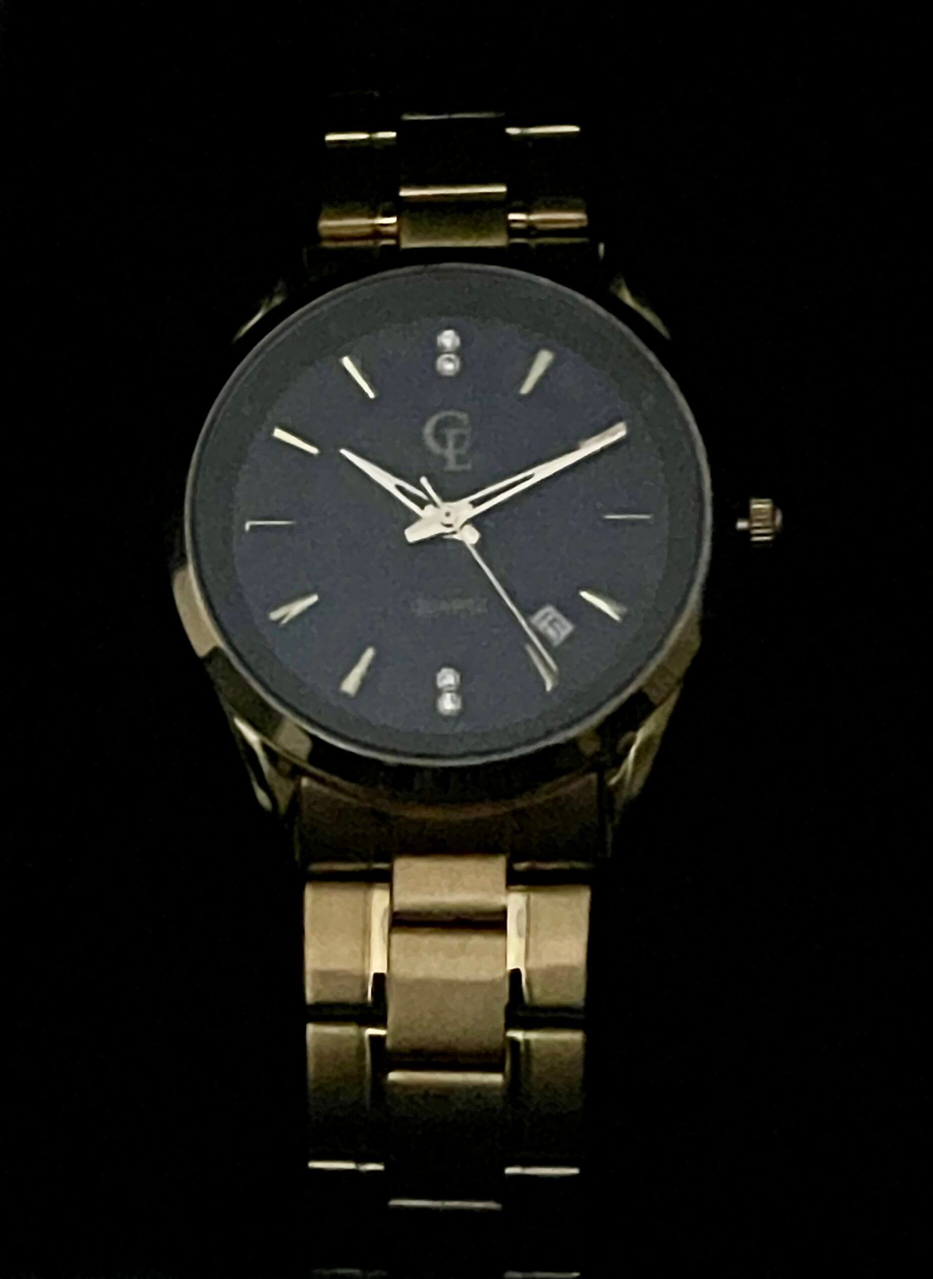 Gold-toned wristwatch with a dark blue face and diamond hour markers, set against a black backdrop.