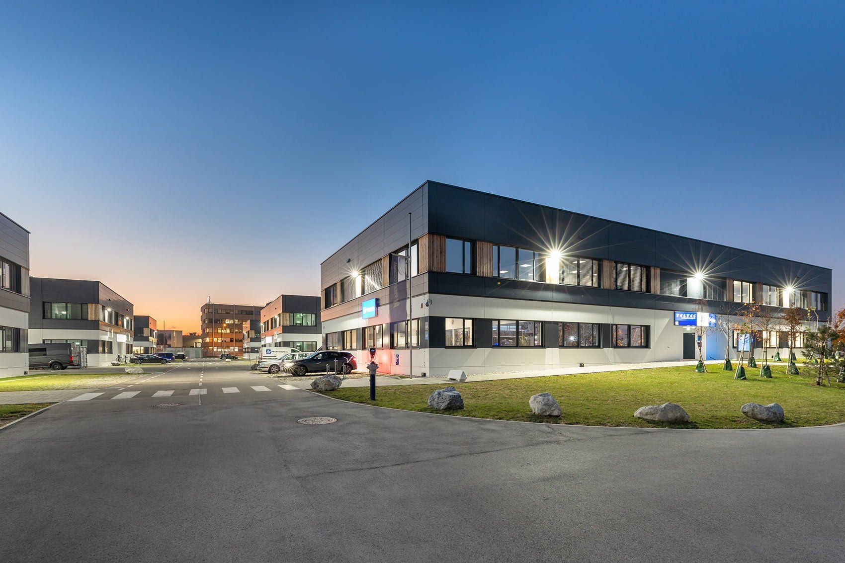 A large building with a lot of windows and a lot of cars parked in front of it.