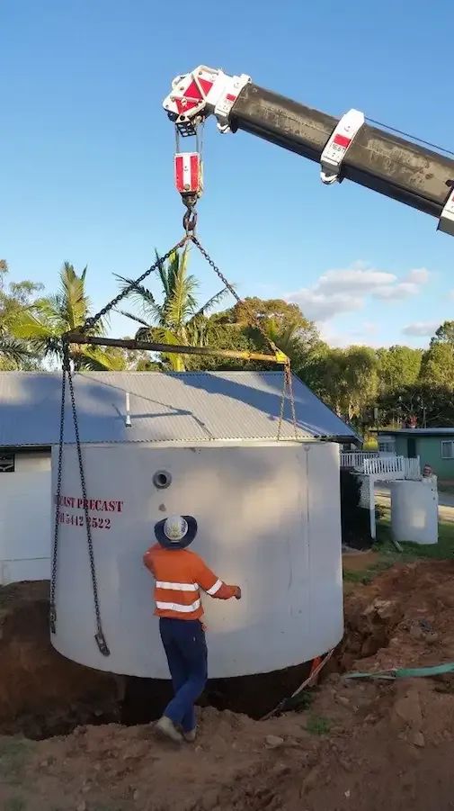 A Crane Lowers a Large, Cylindrical Concrete Tank — Enviroplumb & Gas in Gracemere, QLD