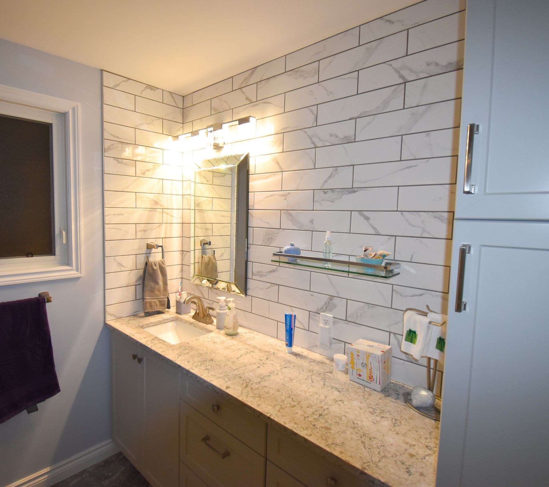 A bathroom with white brick walls and a sink