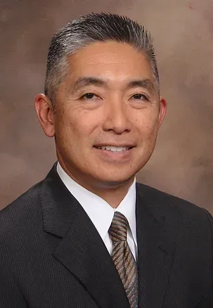 A man in a suit and tie is smiling for the camera.