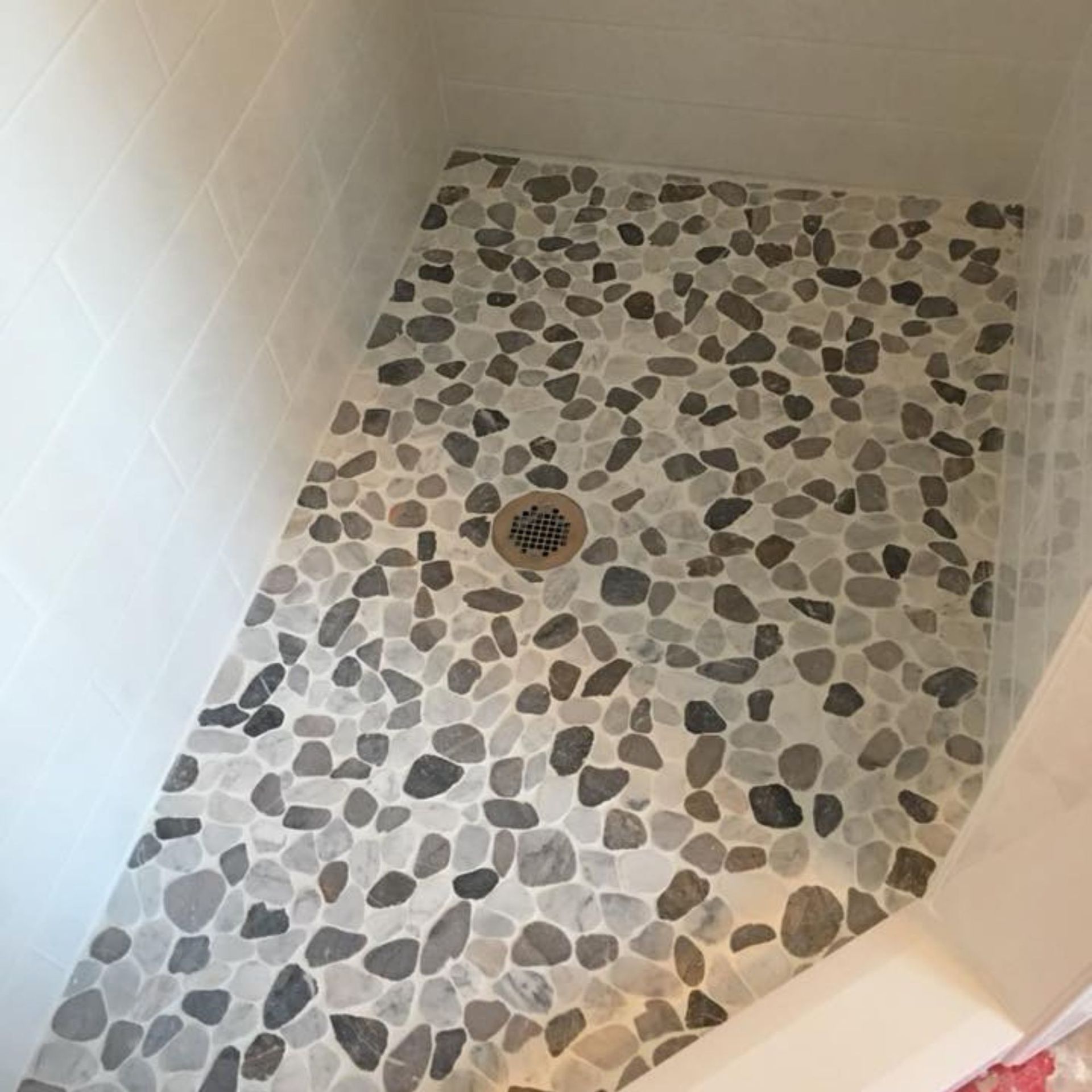 Masters Touch Roofing - A shower stall with a tiled floor and a drain