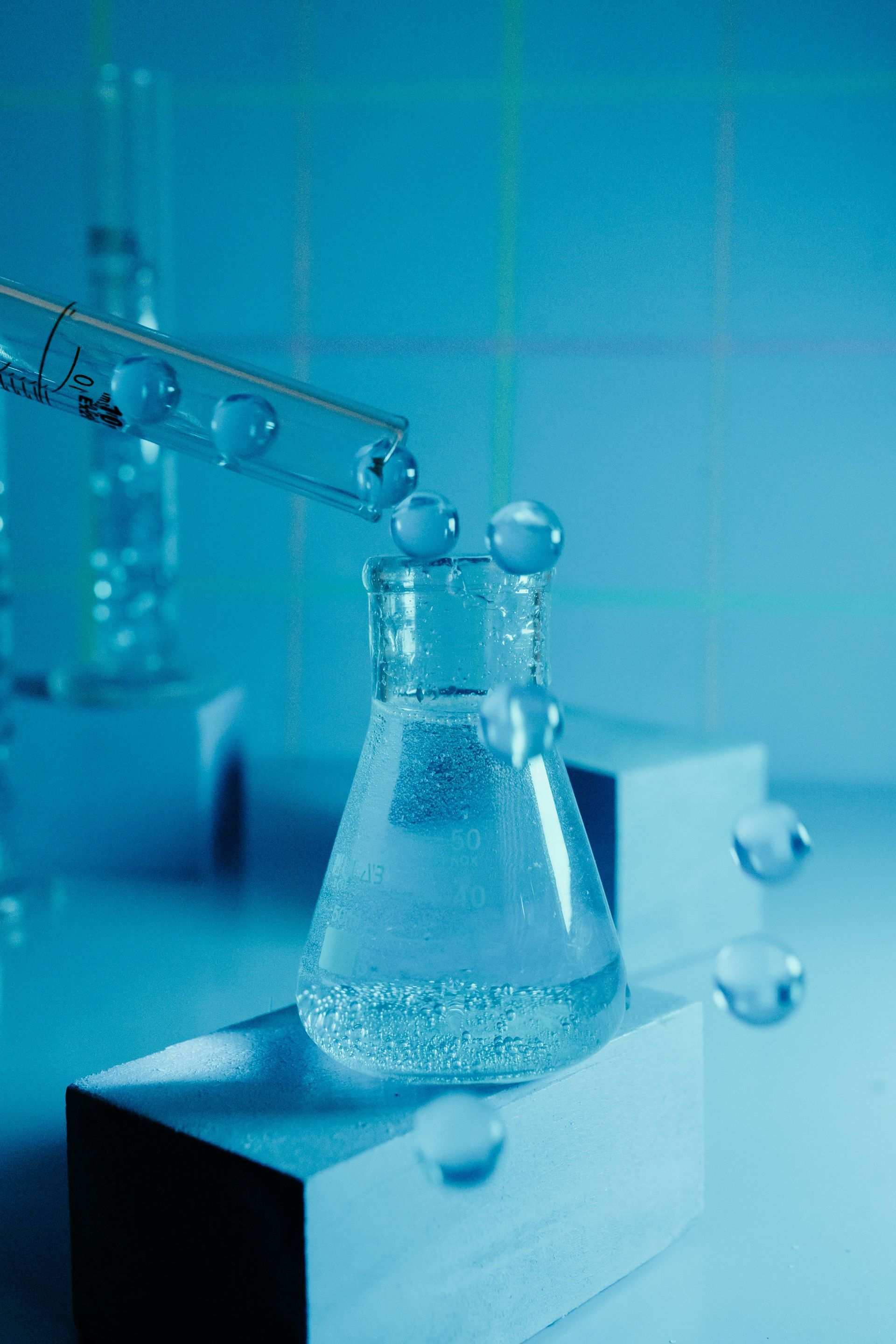 A beaker filled with liquid is being poured into another beaker.