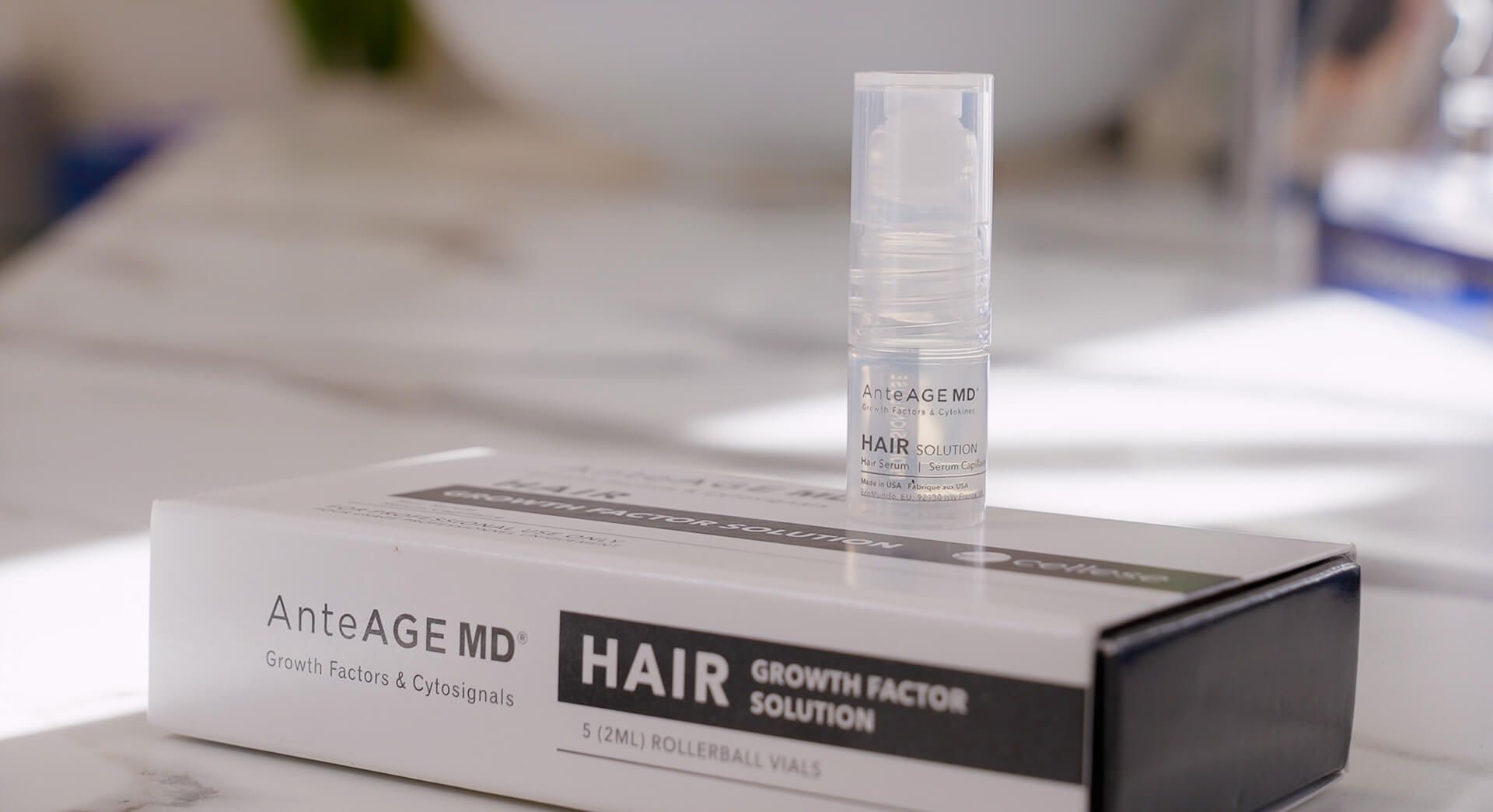A bottle of hair growth solution is sitting on top of a box.