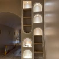 Built-in arched wall shelves with warm recessed lighting in a modern interior