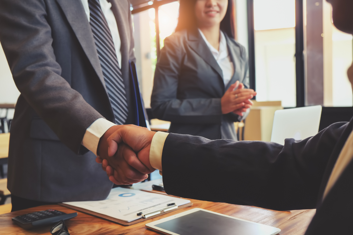 A group of business people are shaking hands in an office.