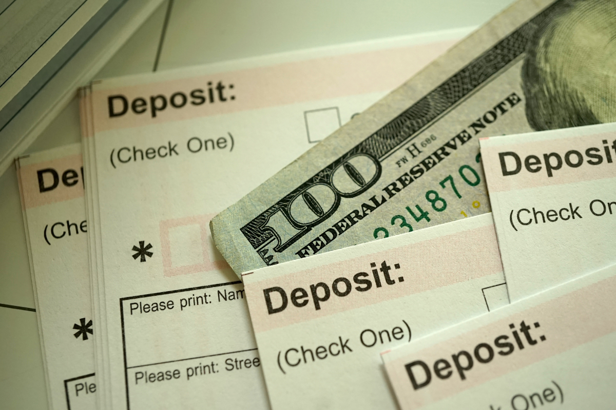 A 100 dollar bill is laying on top of a deposit form