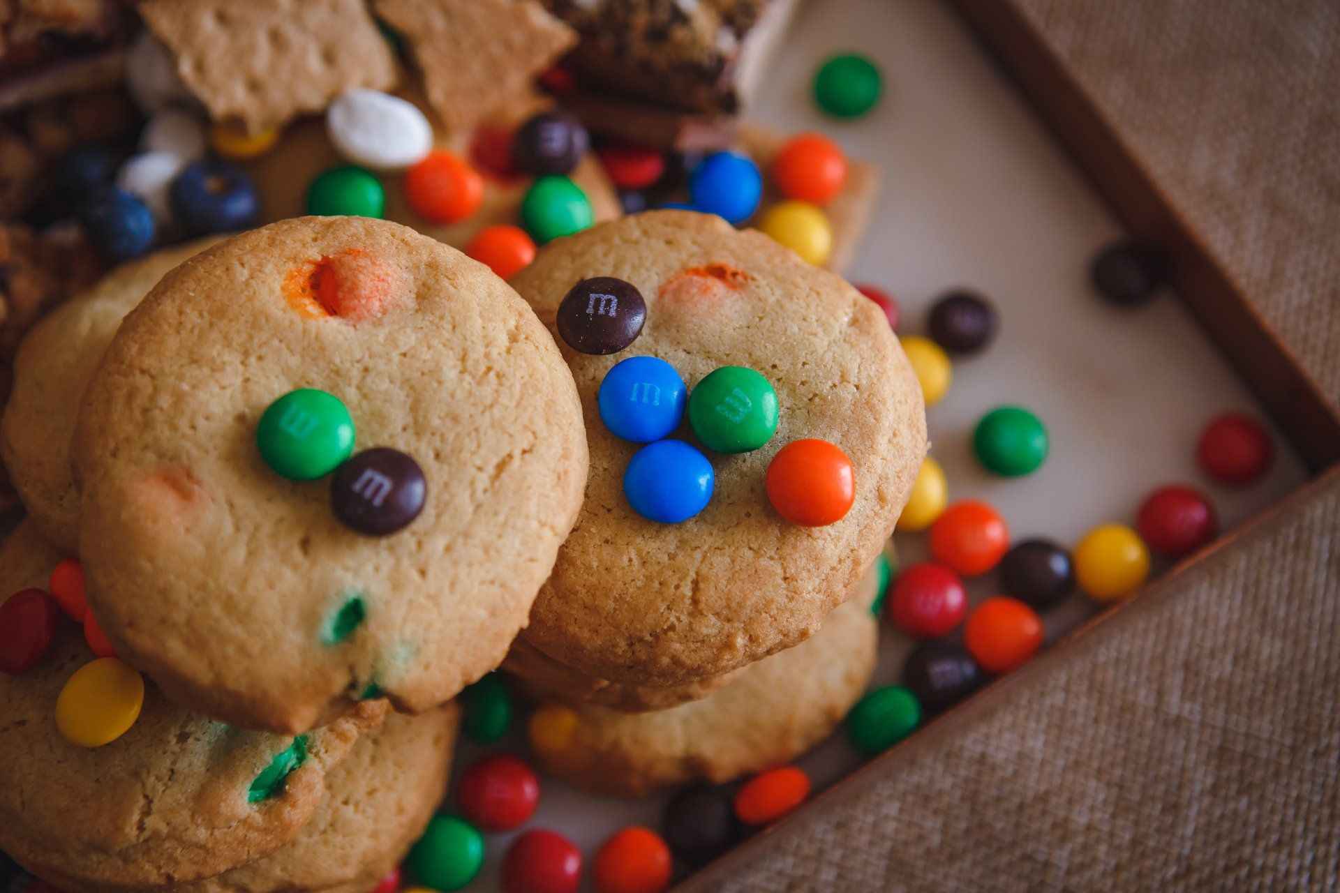 A stack of cookies with m & m 's on top of them on a table.