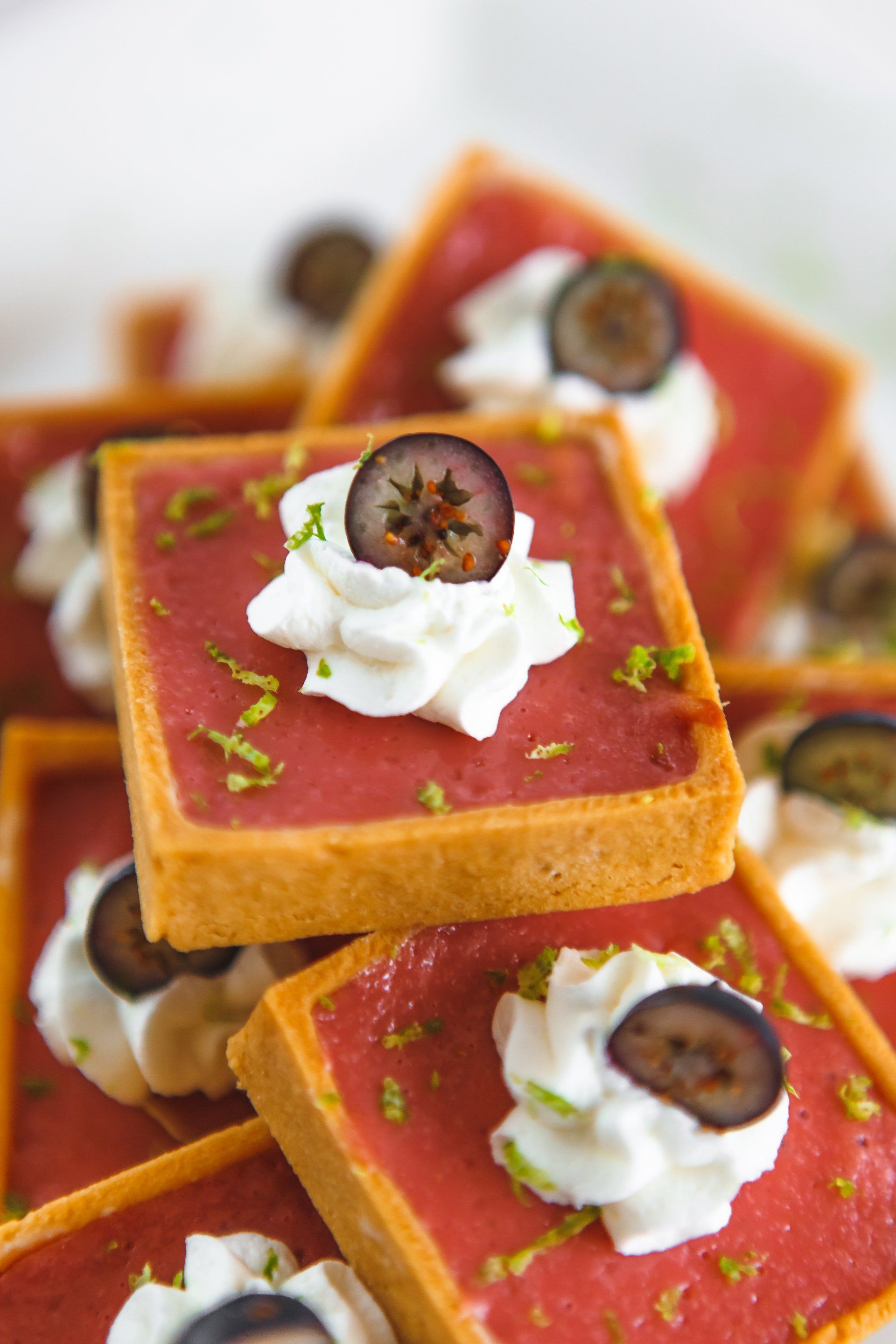 A close up of a dessert with whipped cream and grapes on top.
