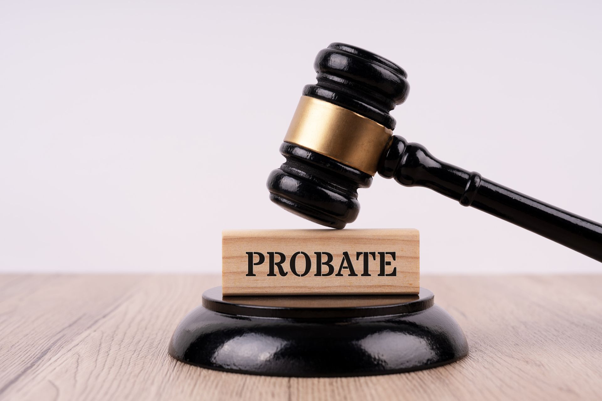 A judge 's gavel is sitting on top of a wooden block with the word probate written on it.