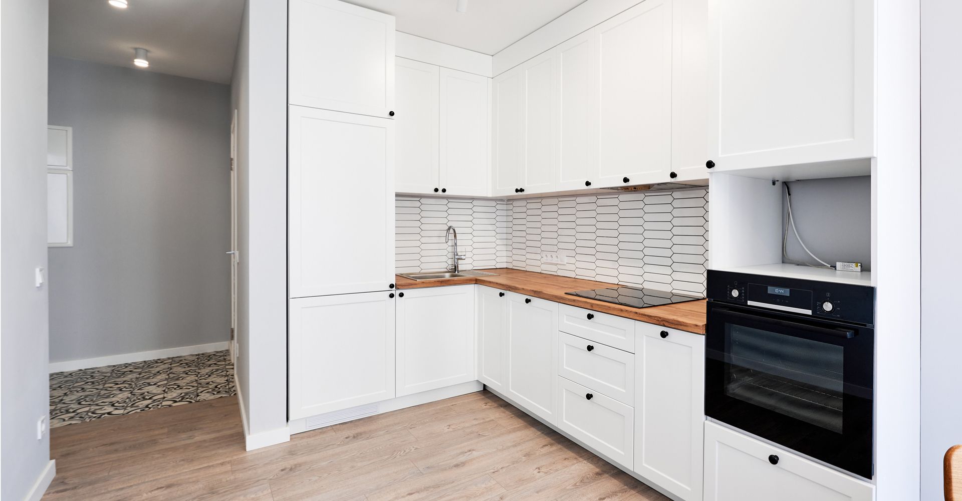 A kitchen with white cabinets and a black oven