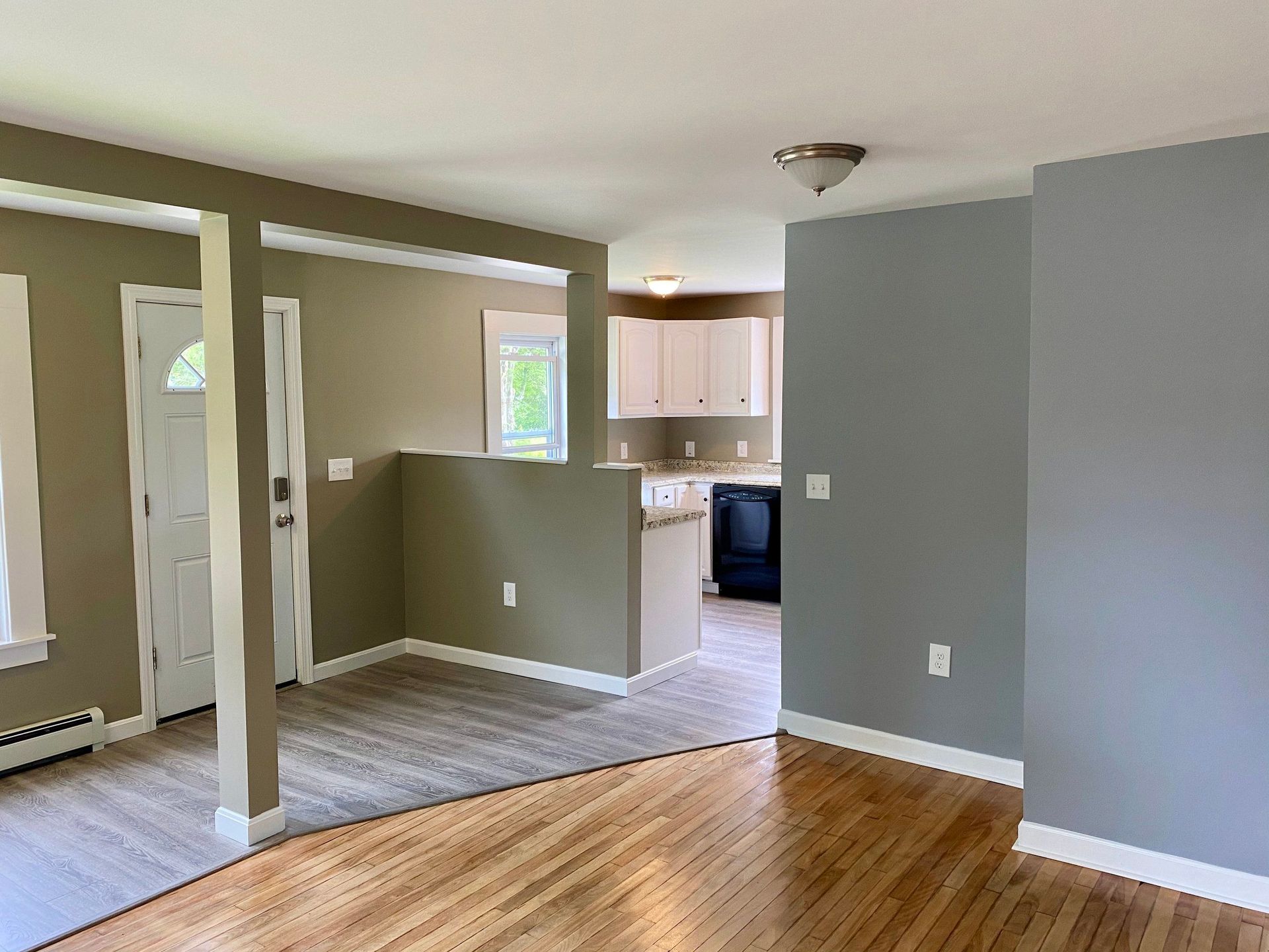 An empty house with gray walls and wooden floors