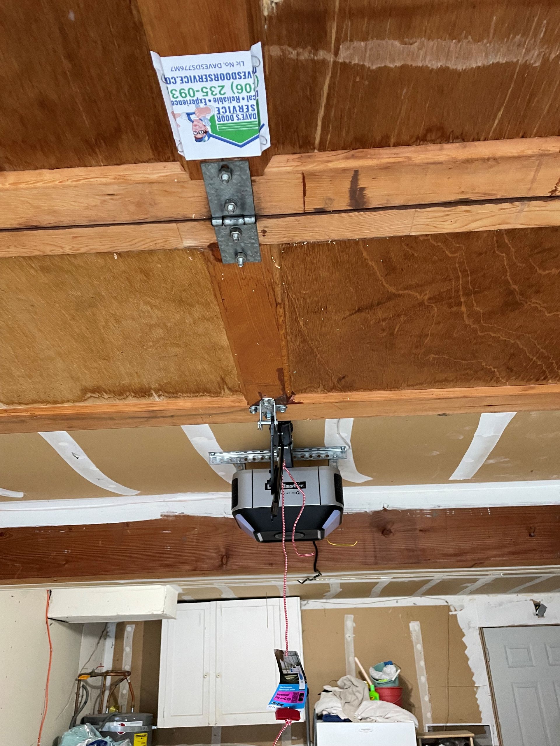 Garage door opener with a bag hanging from it.