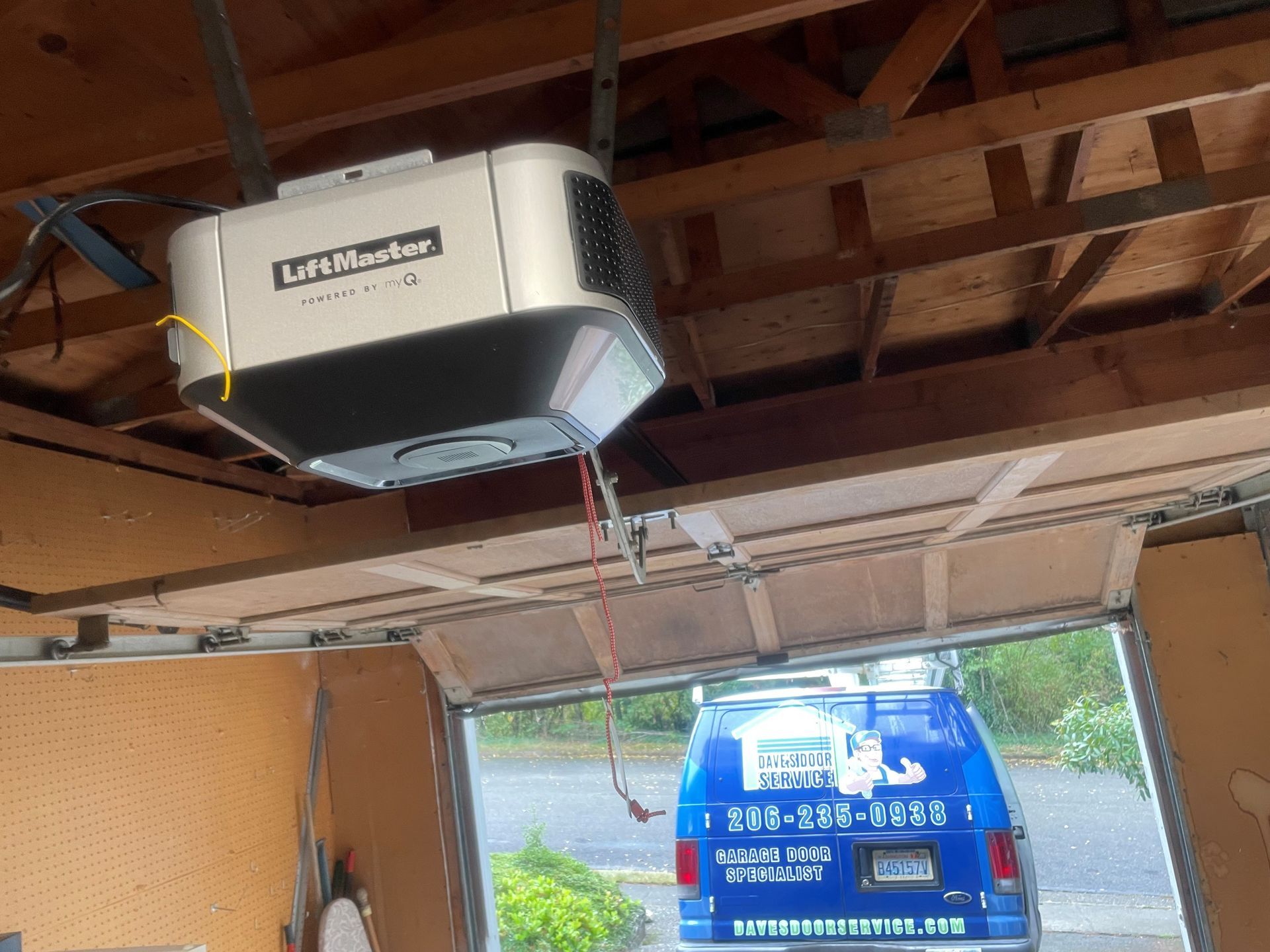 Garage with a LiftMaster opener; blue service van is parked inside.
