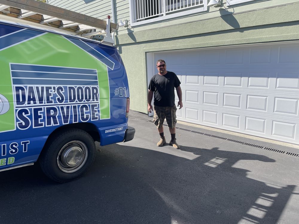 Man stands by garage door with service van,