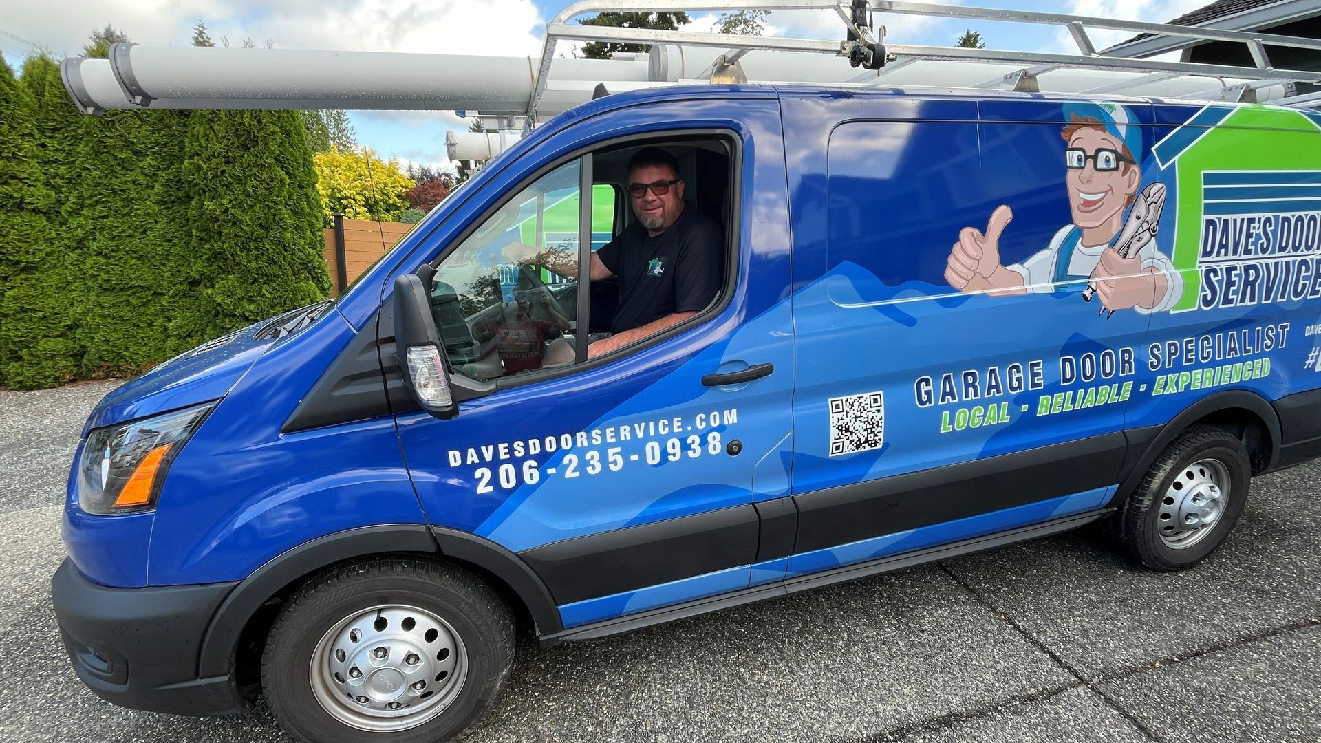 Blue van with business logo; driver visible.