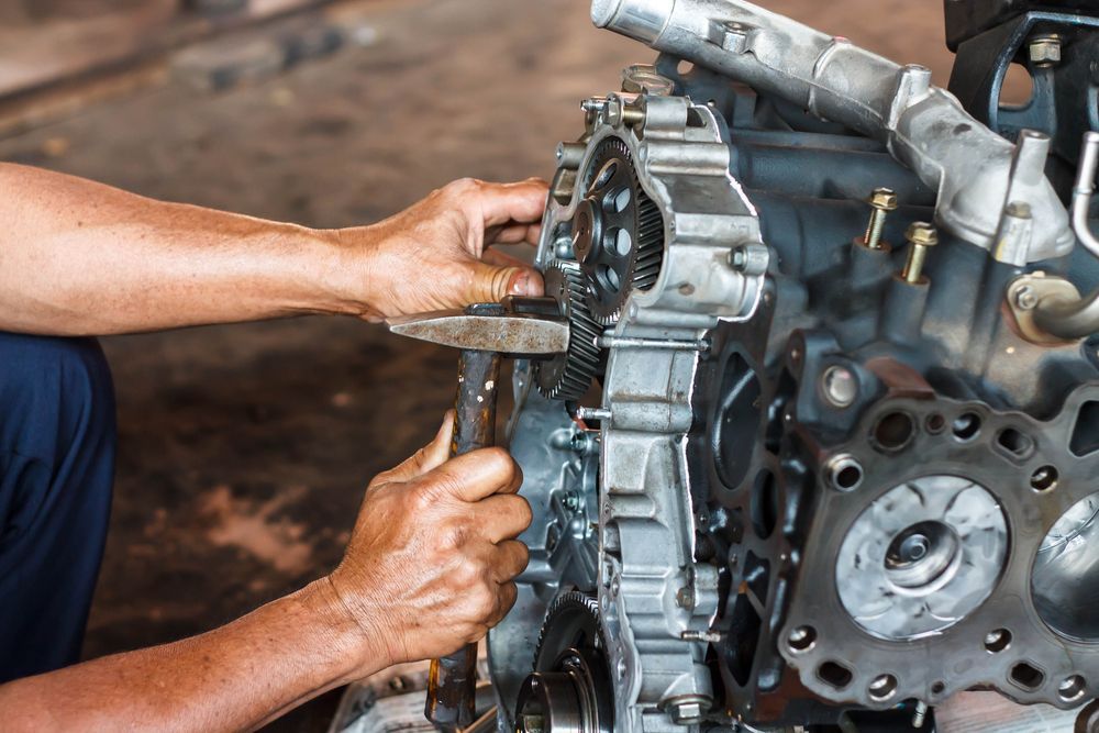 A Man is Working on a Car Engine in a Garage — Unified Mechanical – Mobile Mechanic In Byron Bay, NSW