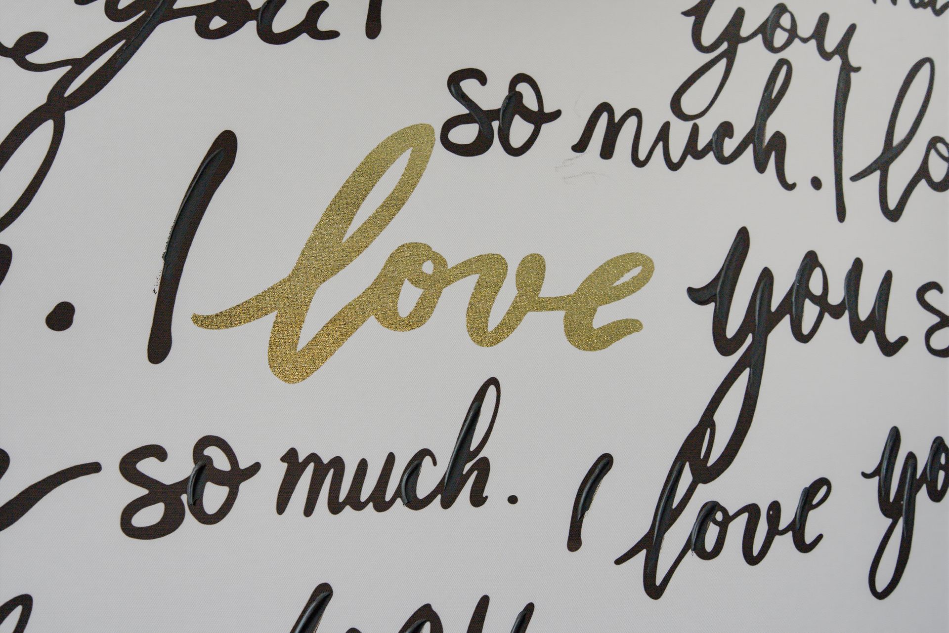 Handwritten “love you so much” in black and gold script on a white background