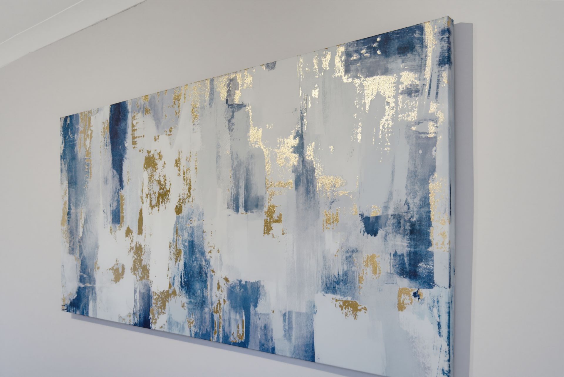 Abstract blue, white, and gold wall painting with textured vertical brushstrokes