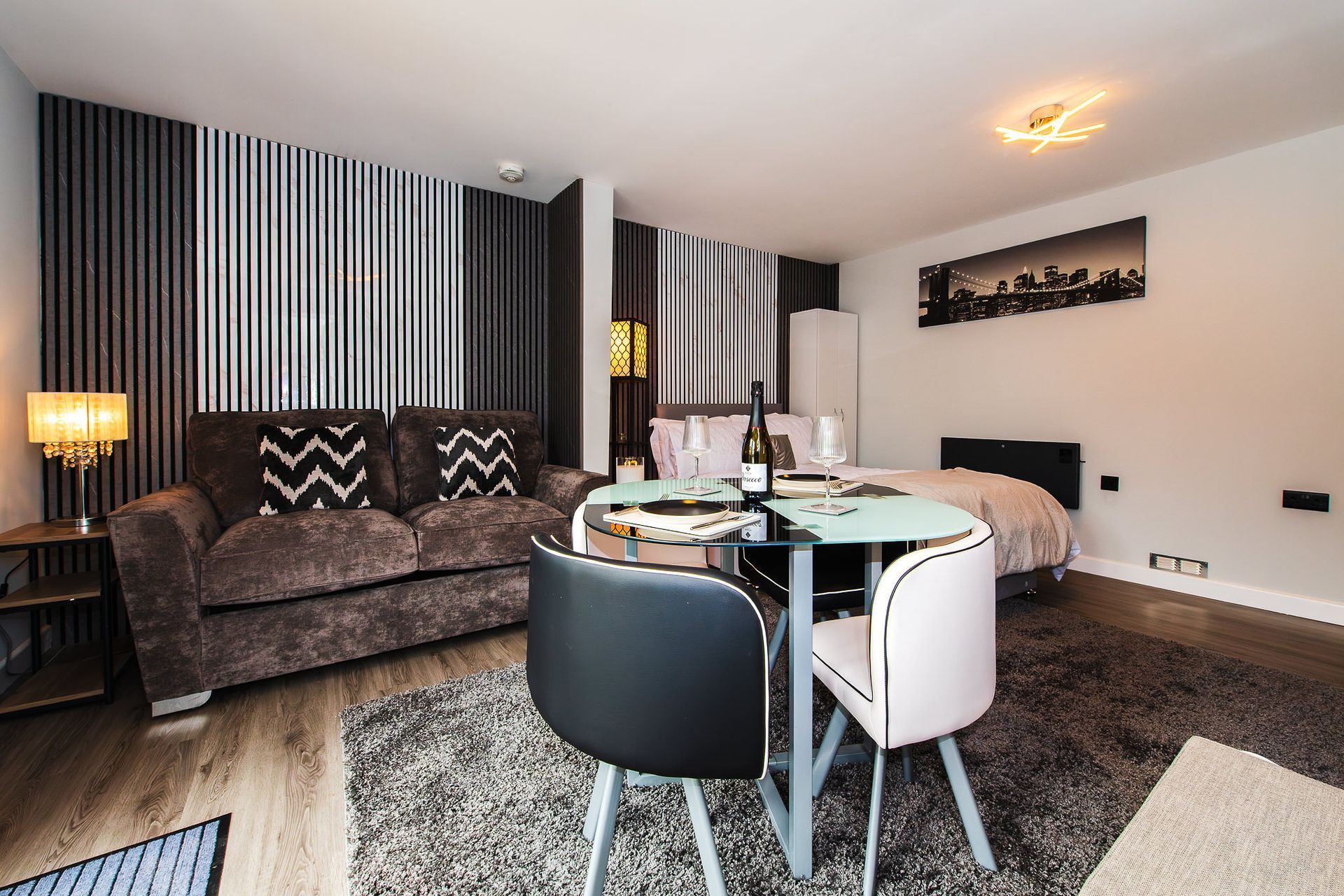 Modern living room with sofa, dining table, striped curtains, and neutral decor