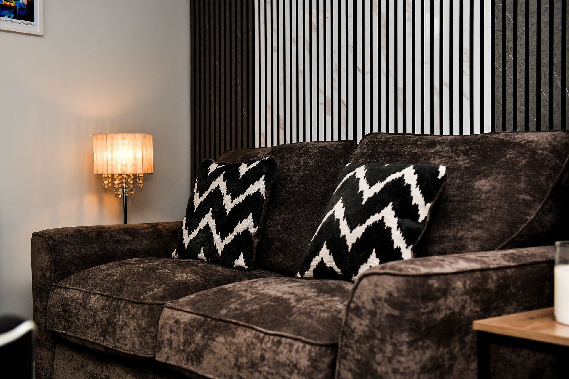 Brown velvet sofa with black-and-white zigzag pillows in a modern living room