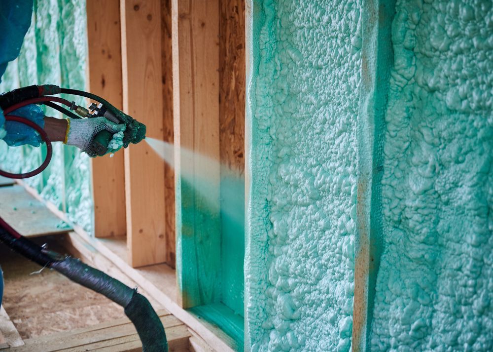 Close-up of a spray foam insulation nozzle applying foam to a wall. Laramie, WY.
