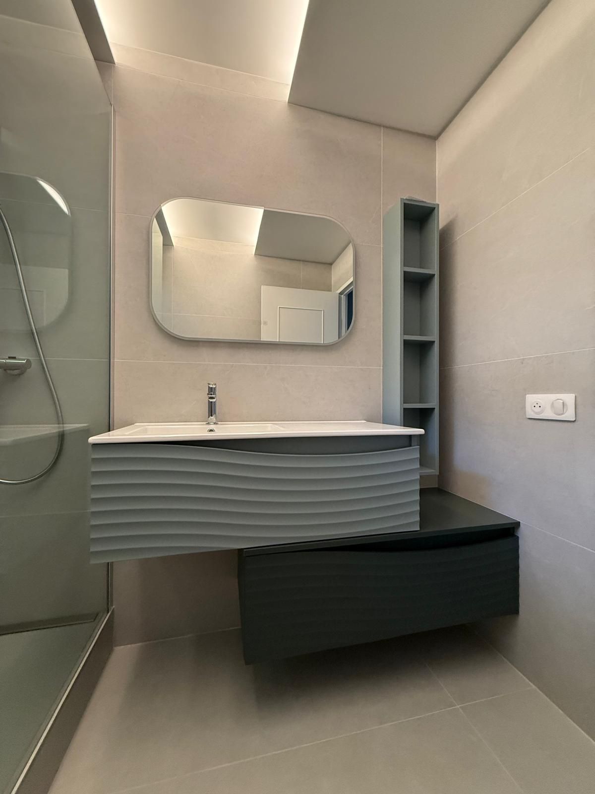 Salle de bains moderne grise avec douche à l'italienne, meuble-lavabo suspendu, miroir et étagères intégrées