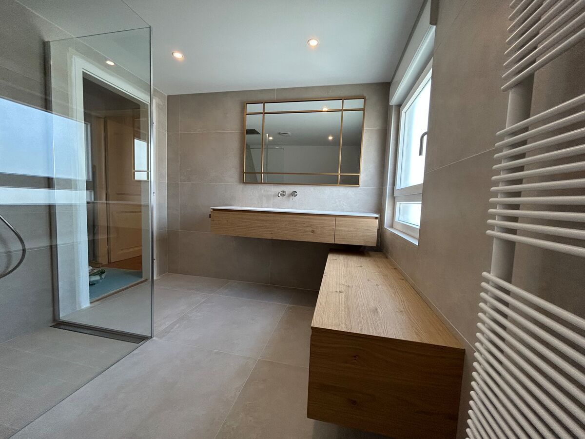 Une salle de bain avec un lavabo, un miroir et un porte-serviettes.
