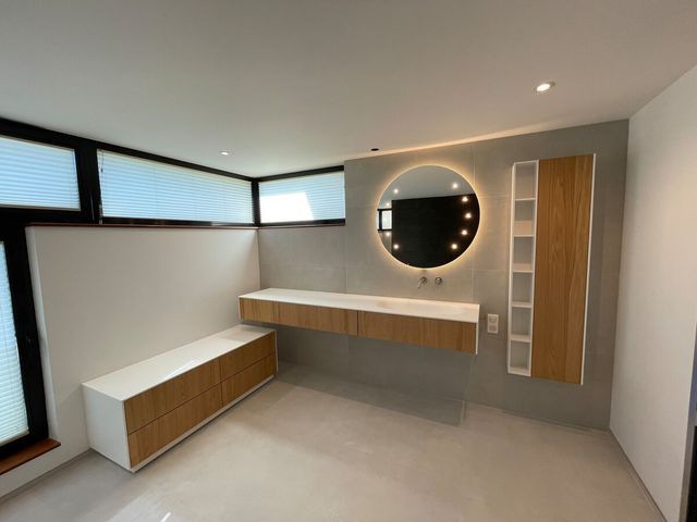 Une salle de bain avec un lavabo, un miroir et des armoires.