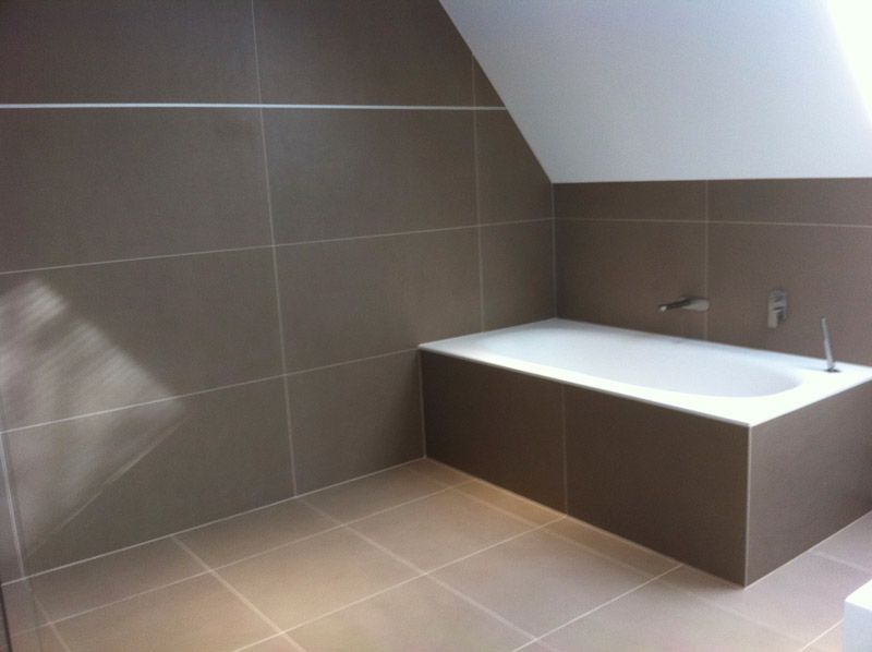 Une salle de bain avec baignoire et murs carrelés