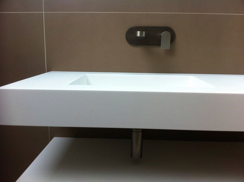 Un lavabo de salle de bain avec un robinet noir sur le mur