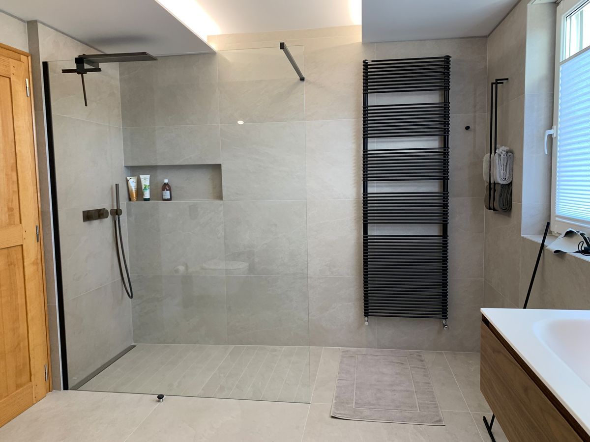 Une salle de bain avec une douche à l'italienne et un porte-serviettes
