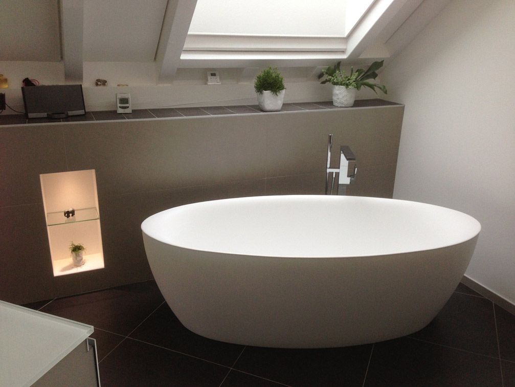 Une baignoire dans une salle de bain avec un puits de lumière au-dessus