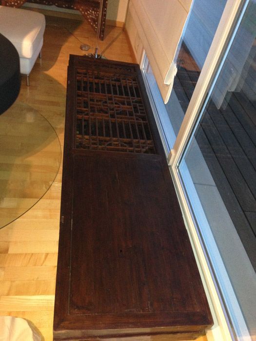 Une table en bois dans un salon à côté d'une porte coulissante en verre
