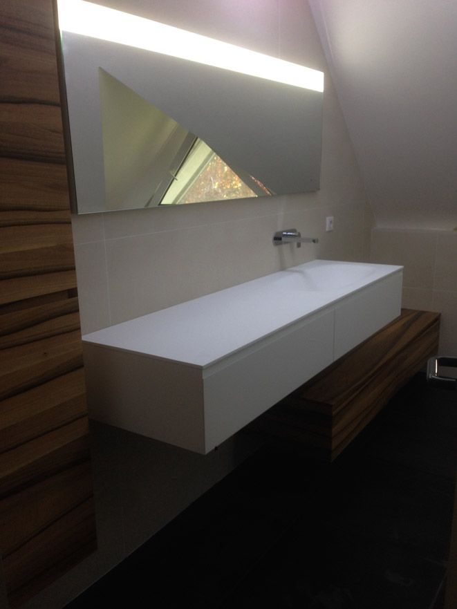 Une salle de bain avec un grand lavabo et un miroir