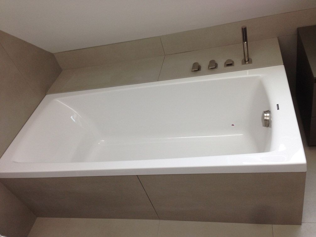 Une baignoire blanche dans une salle de bain avec une pomme de douche