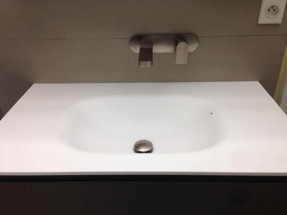 Un lavabo de salle de bain avec un robinet en acier inoxydable
