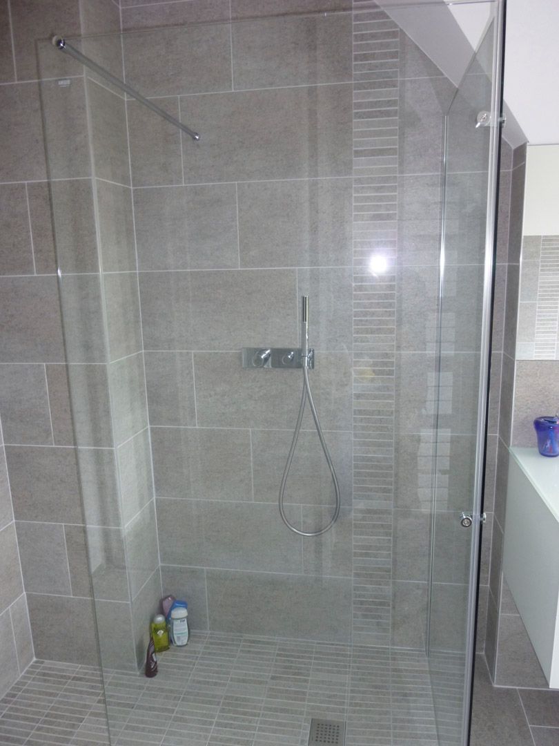 Une salle de bain avec une douche à l'italienne avec une porte vitrée